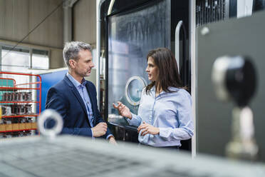 Businessman and businesswoman having a work meeting in a factory - DIGF10221