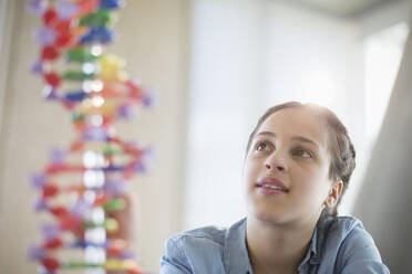 Nachdenkliche Schülerin bei der Untersuchung eines DNA-Modells im Klassenlabor - CAIF26504