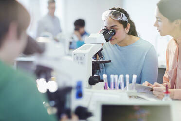 Studentin mit Mikroskop, die ein wissenschaftliches Experiment im Laboratorium durchführt - CAIF26521