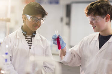 Junge Studenten, die eine Flüssigkeit im Reagenzglas untersuchen und ein wissenschaftliches Experiment im Labor durchführen - CAIF26539