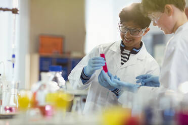 Junge Studenten, die ein wissenschaftliches Experiment durchführen und eine Flüssigkeit in einem Reagenzglas in einem Laboratorium untersuchen - CAIF26552