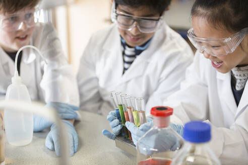 Schüler untersuchen Flüssigkeiten in einem Reagenzglasregal und führen ein wissenschaftliches Experiment in einem Laboratorium durch - CAIF26583