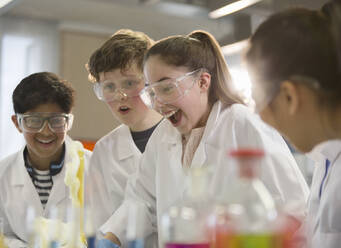 Surprised students conducting exploding foam scientific experiment in classroom laboratory - CAIF26592