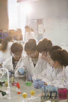 Studenten führen ein wissenschaftliches Experiment durch, indem sie eine Flüssigkeit in einen Becher im Laboratorium gießen - CAIF26600