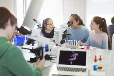 Studentin mit Mikroskop, die ein wissenschaftliches Experiment im Laboratorium durchführt - CAIF26615