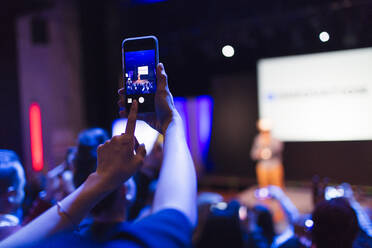 Frau mit Fotohandy, die eine Konferenzpräsentation fotografiert - CAIF26684