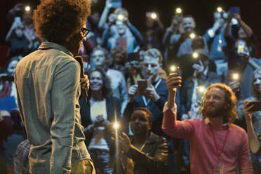 Publikum benutzt Smartphone-Taschenlampen und beobachtet den Sprecher - CAIF26702