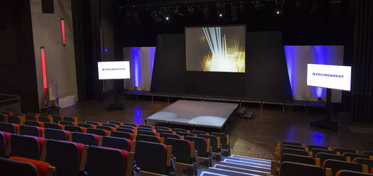 Projection screens and seats in empty conference auditorium - CAIF26710