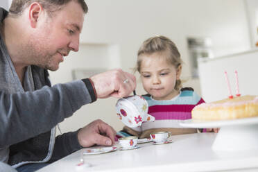 Father and daughter playing with doll's china set - SDAHF00755