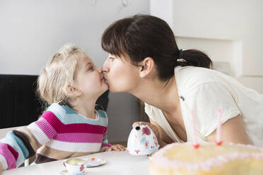 Mother and daughter playing with doll's china set, kissing each other - SDAHF00756