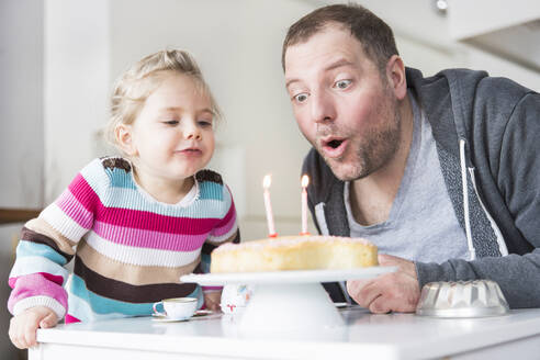 Vater und Tochter blasen Geburtstagskerzen aus - SDAHF00758