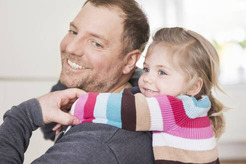 Vater kuschelt mit seiner Tochter zu Hause - SDAHF00774