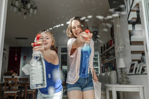 Two sisters splashing with window cleaner - OGF00300