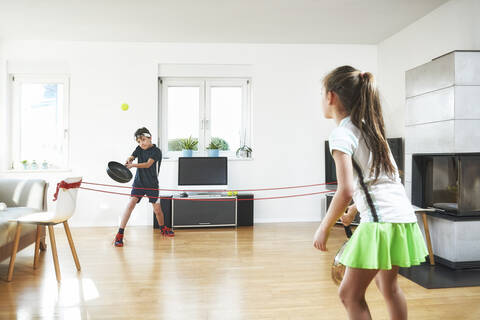 Siblings enjoying tennis at home during pandemic situation stock photo