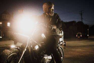 Mann auf Motorrad bei Nacht - HWHF00021