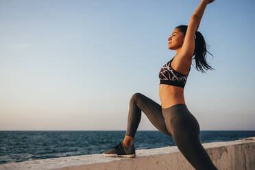 Weibliche Athletin übt Yoga an der Promenade bei Sonnenaufgang - OYF00135