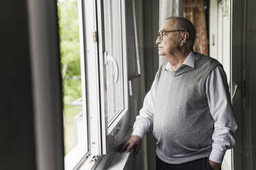 Nachdenklicher älterer Mann schaut aus dem Fenster - UUF20215