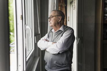 Nachdenklicher älterer Mann schaut aus dem Fenster - UUF20216