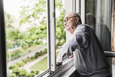 Älterer Mann schaut aus dem Fenster - UUF20217