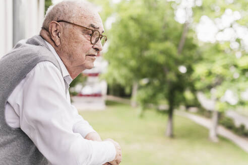 Älterer Mann auf Balkon mit Blick in die Ferne - UUF20225