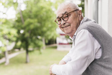 Portrait of smiling senior man on balcony - UUF20226