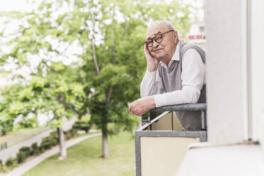 Portrait of smiling senior man standing on balcony - UUF20229