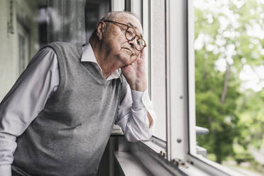 Porträt eines traurigen älteren Mannes, der aus dem Fenster schaut - UUF20230