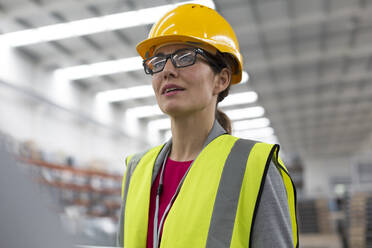 Female worker looking away in factory - CAIF26770