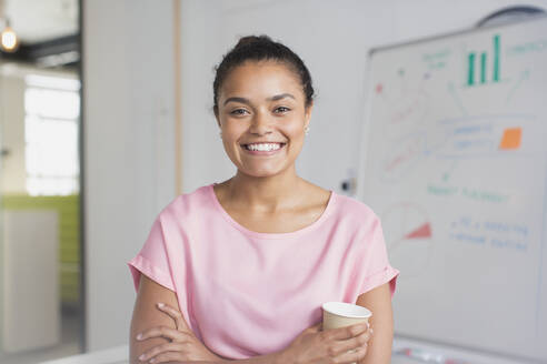 Porträt einer selbstbewussten, enthusiastischen Geschäftsfrau am Whiteboard im Konferenzraum - CAIF26817