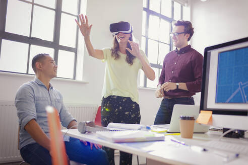 Begeisterte Computerprogrammierer testen Virtual-Reality-Simulatorbrille im Büro - CAIF26819