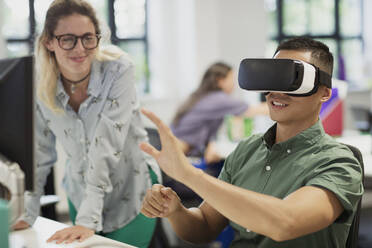 Computer programmers testing virtual reality simulator glasses in office - CAIF26834