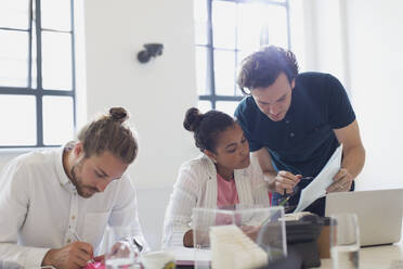 Architects discussing paperwork in conference room meeting - CAIF26844