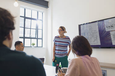 Female architect at television screen leading conference room meeting - CAIF26868