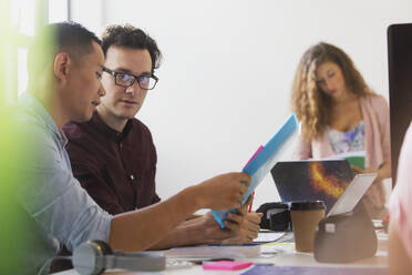 Business people discussing paperwork in conference room meeting - CAIF26891