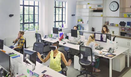 Designers working at desks in open plan office - CAIF26917