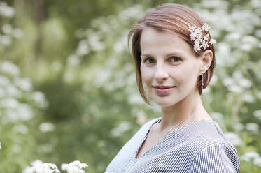 Nahaufnahme einer Frau mit Blumen im Park - EYAF01053