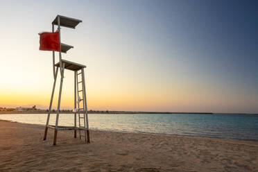 Egypt, Hurghada, Empty lifeguard chair standing on sandy coastal beach of Sahl Hasheesh bay at sunset - TAMF02204