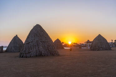 Ägypten, Hurghada, Strohhütten am Sandstrand der Sahl Hasheesh Bucht bei Sonnenaufgang - TAMF02207