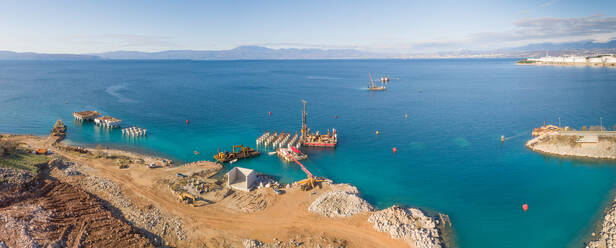Panoramablick auf Maschinen auf Betonplattformen beim Bau des künftigen LNG-Terminals am Ufer der Bucht von Omisalj, Kroatien - AAEF08037