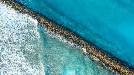 Aerial view of waves breaking at the stone walls of the harbour entry of the local / inhabited island Vashafaru, Haa Alif Atoll, Maldives, Indian Ocean - AAEF08299