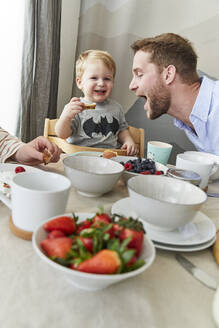 Porträt eines fröhlichen kleinen Jungen, der mit seinem Vater am Frühstückstisch Spaß hat - FSF01045