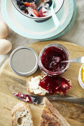 Brot mit Marmelade und eine Schale mit Obstmüsli auf dem Frühstückstisch - FSF01064