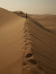 Woman on the ridge of a dune in the desert, Walvis Bay, Namibia - VEGF02071