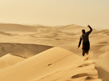 Mann läuft auf einer Düne in der Wüste, Düne 7, Walvis Bay, Namibia - VEGF02084