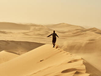 Man running on a dune in the desert, Dune 7, Walvis Bay, Namibia - VEGF02085