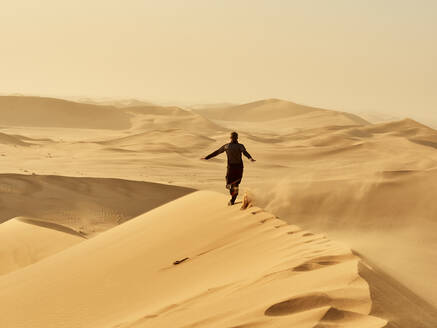 Mann läuft auf einer Düne in der Wüste, Düne 7, Walvis Bay, Namibia - VEGF02085