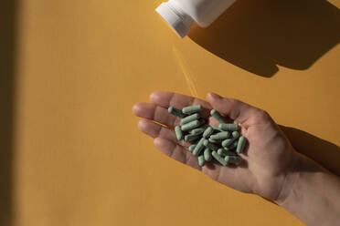 Female hand full of supplement capsules - MOMF00862