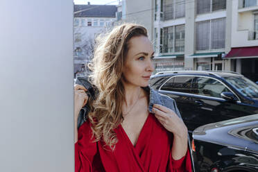 Portrait of woman in red dress in the city - OGF00310