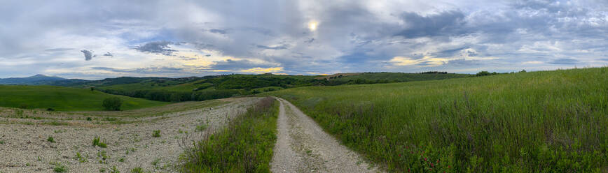 Italien, Provinz Perugia, Gubbio, Wolkenpanorama über leerer Landstraße in der Frühlingsdämmerung - LOMF01050