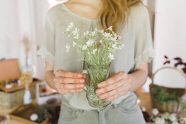 Junge Frau hält Vase mit frischen Blumen - AFVF06188